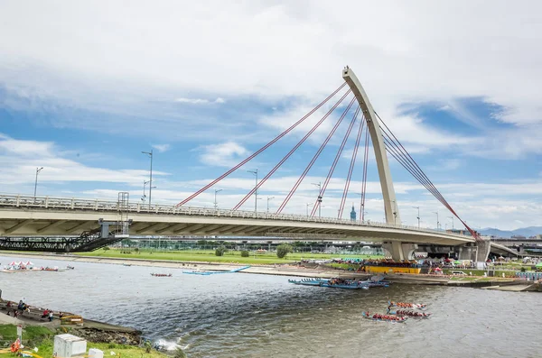 Городской пейзаж с соревновательными лодками под мостом — стоковое фото