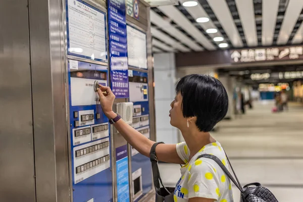 Жінка купує в квитковій машині на вокзалі — стокове фото