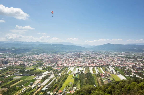 Kleurrijke paragliding over de blauwe lucht in de stad — Stockfoto