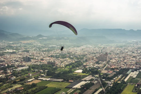 Kleurrijke paragliding over de blauwe lucht in de stad — Stockfoto