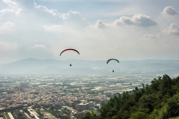 Colorful paragliding over blue sky at town — Stock Photo, Image