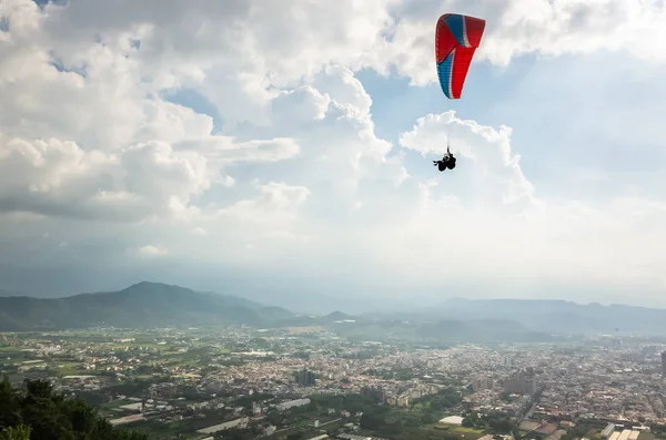 Kleurrijke paragliding over de blauwe lucht in de stad — Stockfoto