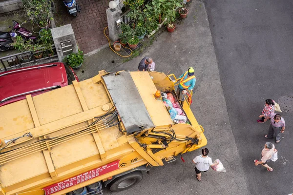 Camión de basura amarillo para recoge basuras en los carriles pequeños en —  Fotos de Stock