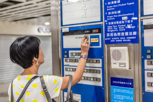 Woman buying at ticket machine in the train station — Stock Photo, Image