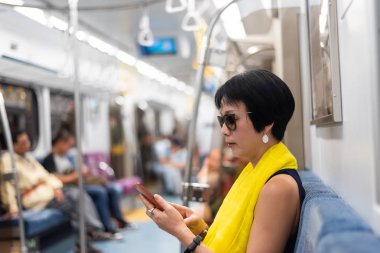 Mrt vagonunda akıllı telefon kullanan kadın
