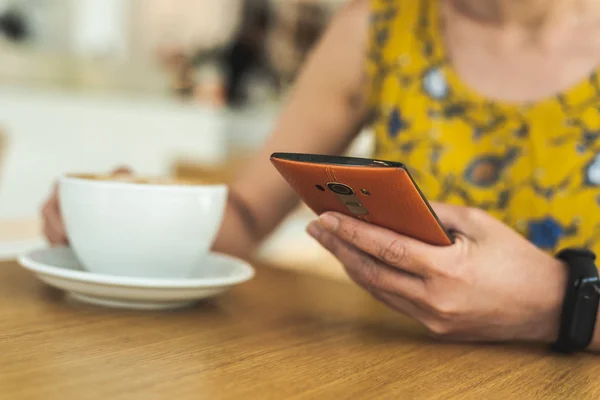 Bir kafede cep telefonu kullanan kadın — Stok fotoğraf