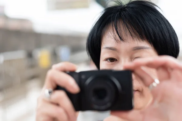 Dospělá asijská žena používající digitální fotoaparát — Stock fotografie