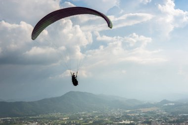 şehirde mavi gökyüzü üzerinde renkli yamaç paraşütü