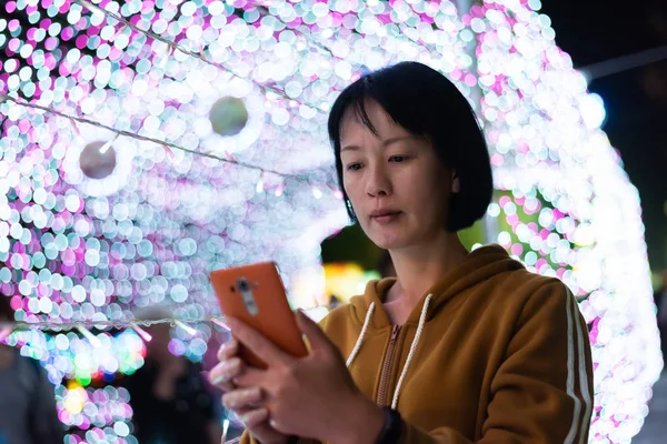 Mujer usando el teléfono celular por la noche — Foto de Stock