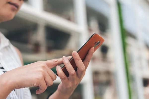 Frau sitzt und benutzt Handy — Stockfoto