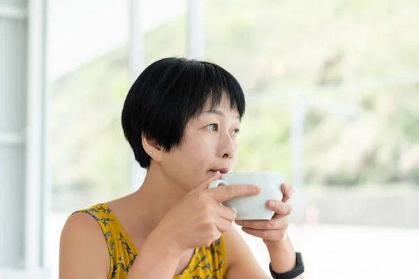 Mulher asiática segurar uma xícara de café — Fotografia de Stock