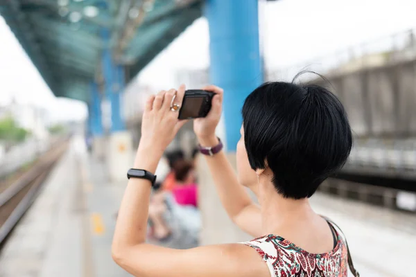 成熟的亚洲妇女使用数码相机 — 图库照片