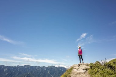 Asyalı dağcı kadın uzaklara bakıyor