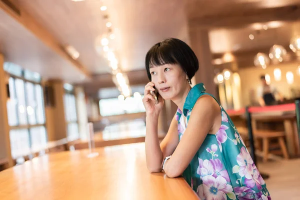 Vrouw praat op mobiele telefoon in een koffieshop — Stockfoto