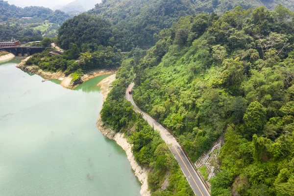 明丹貯水池の湖の近くに木々が植わる道路 — ストック写真