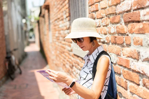 女性は古い通りで地図をチェックする — ストック写真