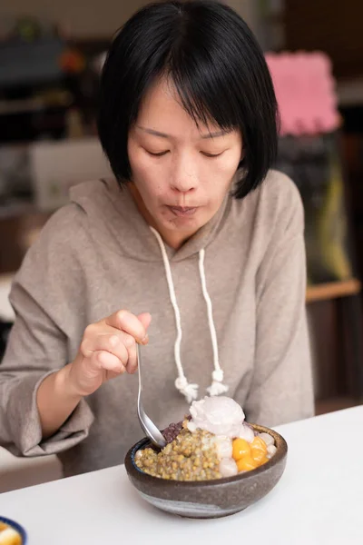Aziatische vrouw eet geschoren ijs — Stockfoto
