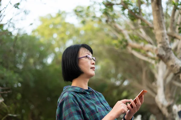 Взрослая азиатка с мобильником — стоковое фото