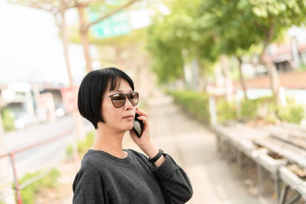 Asyalı kadın cep telefonunuzun konuşma — Stok fotoğraf