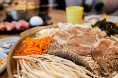 Bir restoranda bakır ızgara tepsisi üzerinde Kore barbeküsü