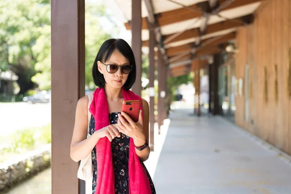 駅の廊下で携帯電話を使う女性は — ストック写真