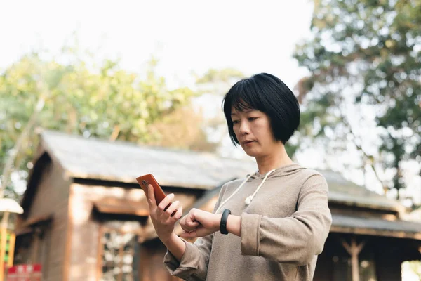 Mogen Asiatisk Kvinna Med Smart Klocka Och Mobiltelefon — Stockfoto