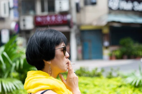 公共の場でタバコを吸っているアジアの女性が — ストック写真