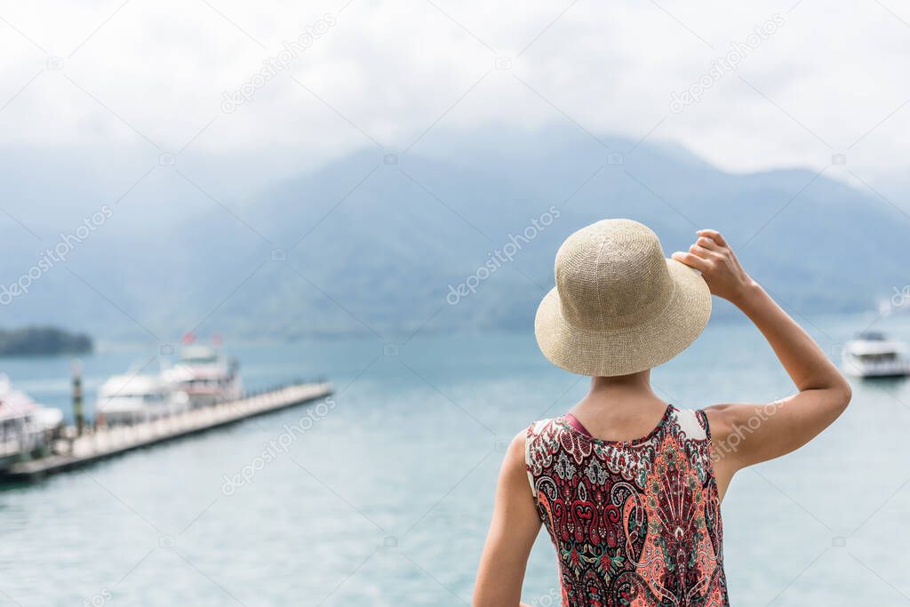 traveling Asian woman with hat standing at Sun Moon Lake, Taiwan