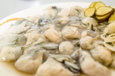 Beyaz tabakta taze istiridyeler, sağlıklı deniz ürünleri.