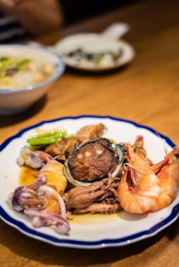 İnsanlar restoranda bir tabak deniz mahsulü yiyorlar.