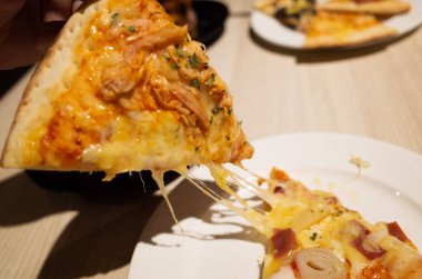 Bir restoranda küçük bir dilim pizza yemek.