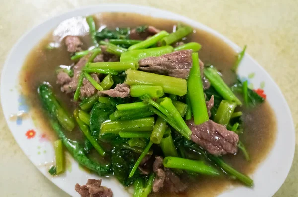 taiwanese snack of beef with water spinach on a plate in a restaurant