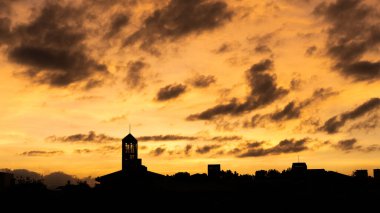 Şehrin siluet kulesinin üzerinde dramatik bulutlarla gün batımı manzarası
