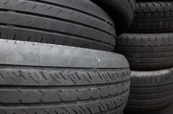 old used car tires stacked in piles in the daytime