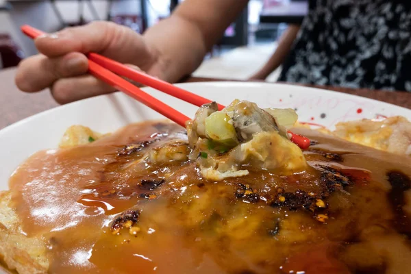 女性は伝統的な台湾の牡蠣のオムレツを食べる — ストック写真