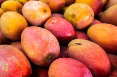 Geleneksel pazarda canlı kırmızı renkli mango meyveleri yığını, Tayvan
