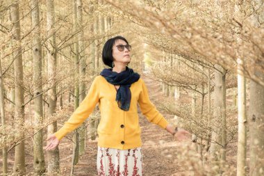 modern olgun Asyalı kadın ormanda kendini özgür hisseder.