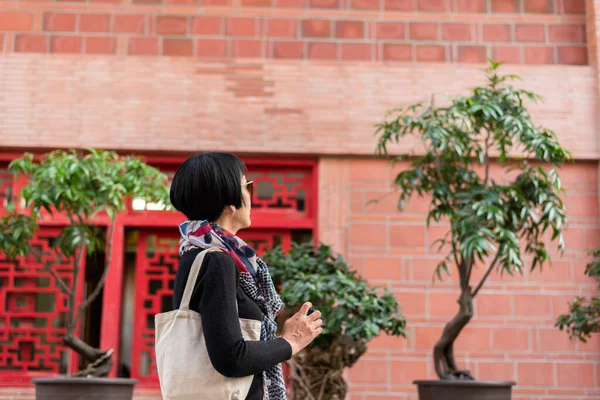现代亚洲女人拿着相机在一座古老的中国建筑物上旅行 — 图库照片