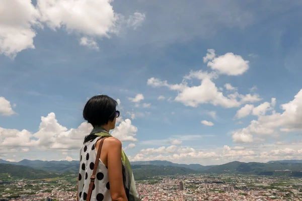 青い空の下の街を丘の上に立つアジアの女性 — ストック写真