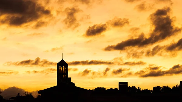 sunset landscape with dramatic clouds over the silhouette tower in a city