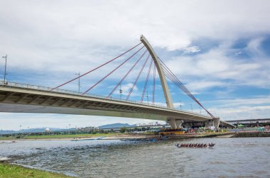 Taipei, Tayvan - 9 Haziran 2019: Taipei, Tayvan, Asya 'da düzenlenen geleneksel Ejderha Teknesi Festivali' nde köprü altında yarışan rekabetçi tekne manzarası