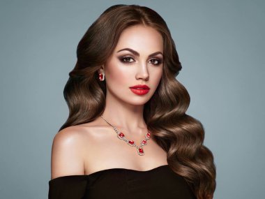 Uzun, sağlıklı ve kıvırcık saçlı esmer kız. Bakım ve Güzellik. Dalgalı saçlı güzel model kadın. Makyaj ve Siyah Elbise