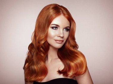 Kızıl saçlı kız uzun sağlıklı ve parlak kıvırcık saçlı. Bakım ve güzellik. Güzel Model kadınla dalgalı saç modeli. Makyaj ve siyah elbise