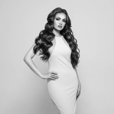 Zarif beyaz gece elbisesi içinde güzel bir kadın. Uzun, sağlıklı ve kıvırcık saçlı esmer kız. Bakım ve Güzellik. Dalgalı Saç Tarzı olan Güzel Model Kadın