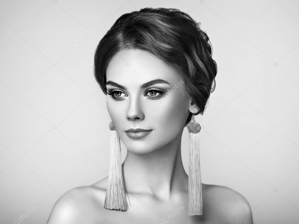 Beautiful Woman with Large Earrings Tassels jewelry. Perfect Makeup and Elegant Hairstyle. Fashion Make-up Arrows. Black and White Photo