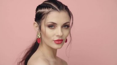 Saçları örgülü esmer kız. Modelin yakın plan portresi. Mükemmel makyaj. Güzel saçlar, moda videoları. Mücevherleri olan güzel kadın. 4k 25fps