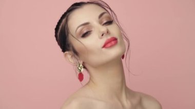 Saçları örgülü esmer kız. Modelin yakın plan portresi. Mükemmel makyaj. Güzel saçlar, moda videoları. Mücevherleri olan güzel kadın. 4k 25fps