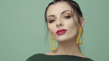 Saçları örgülü esmer kız. Modelin yakın plan portresi. Mükemmel makyaj. Güzel saçlar, moda videoları. Mücevherleri olan güzel kadın. 4k 25fps