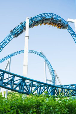 Mavi gökyüzüne karşı lunapark treni. Lunaparktaki lunaparkta hız treni. Eğlence parkında neşeli eğlenceler.