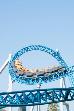 Mavi gökyüzüne karşı lunapark treni. Lunaparktaki lunaparkta hız treni. Eğlence parkında neşeli eğlenceler.